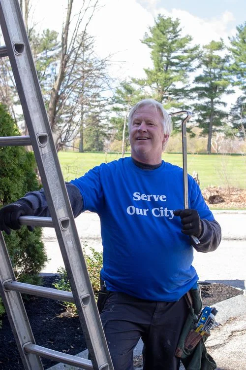 A Northeast Christian Church volunteer wearing a ‘Serve Our City’ shirt doing outdoor service work